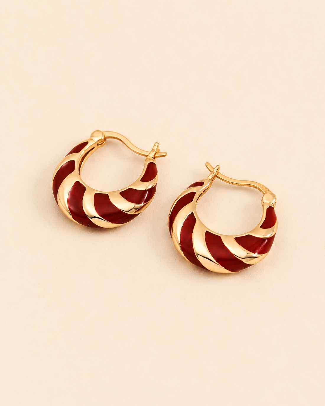 Red enamel hoop earrings crafted in S925 sterling silver with thick 18K gold plating, displayed on a soft ivory background.