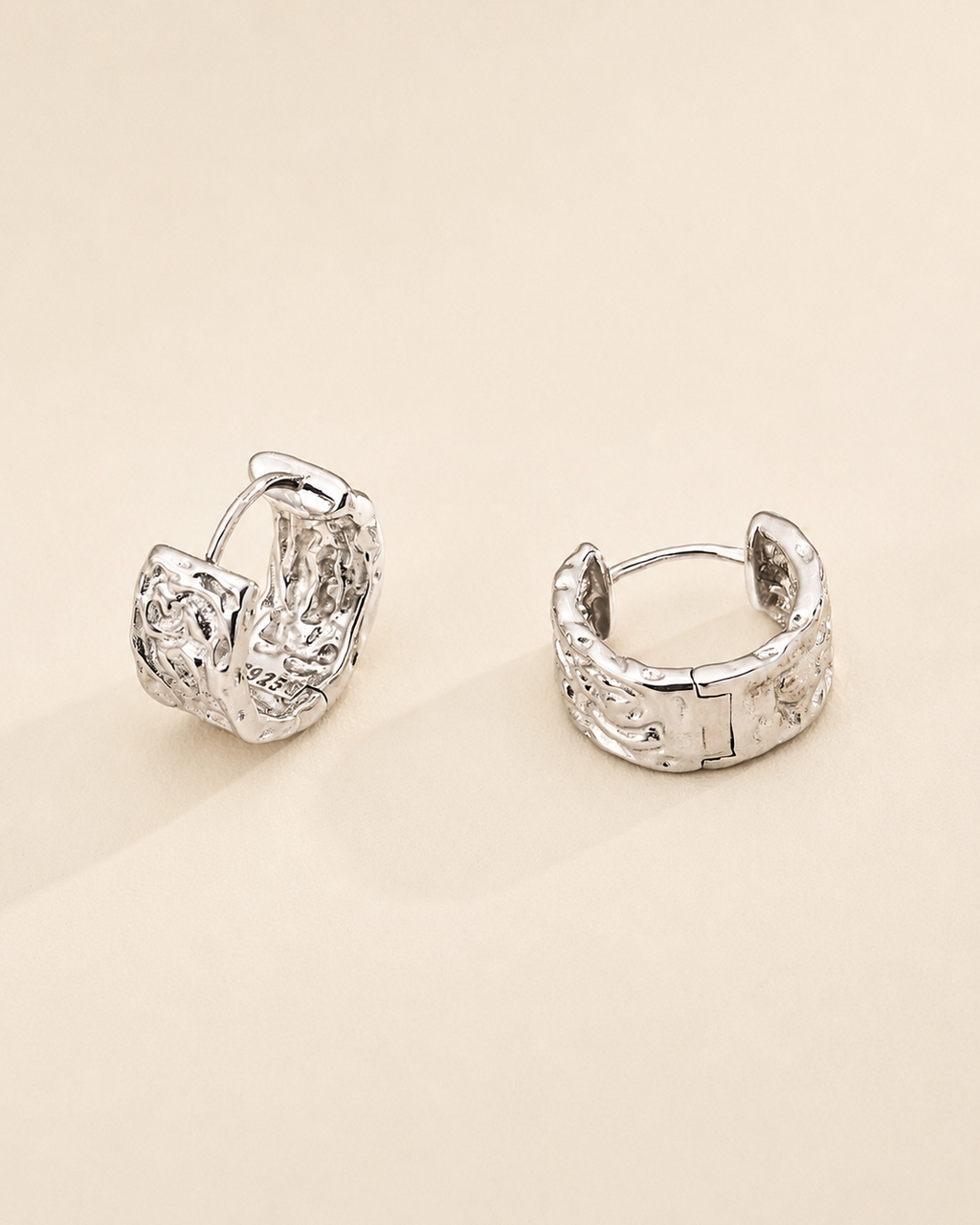 Close-up of a model wearing vintage carved huggie hoop earrings in thick 18K white gold plated sterling silver with an elegant everyday look