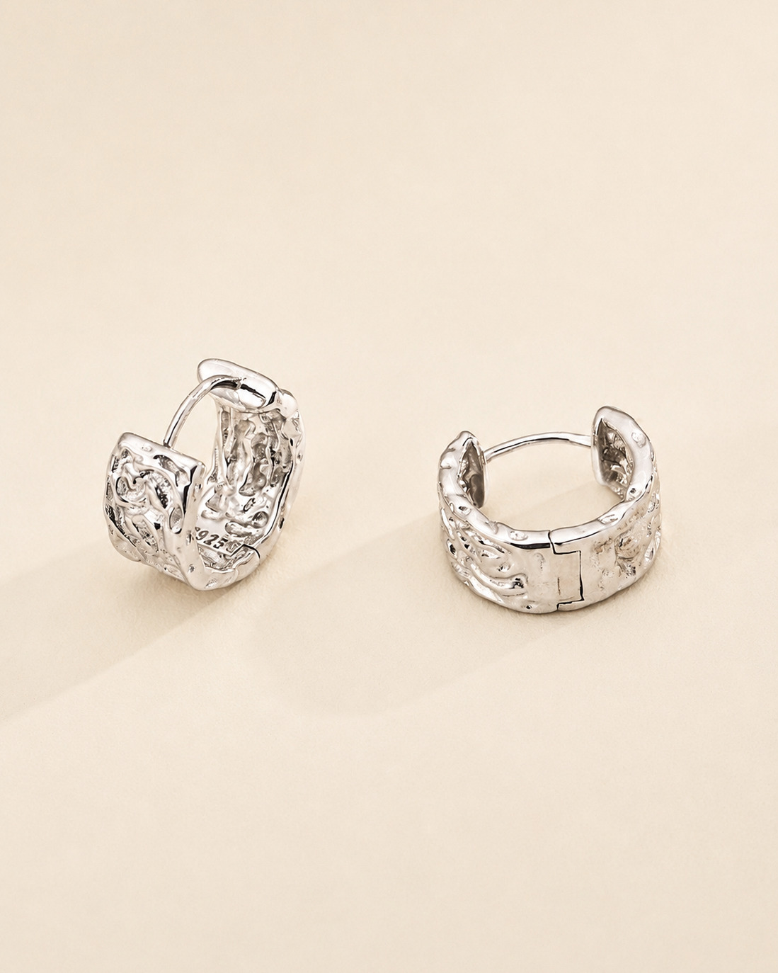 Close-up of a model wearing vintage carved huggie hoop earrings in thick 18K white gold plated sterling silver with an elegant everyday look